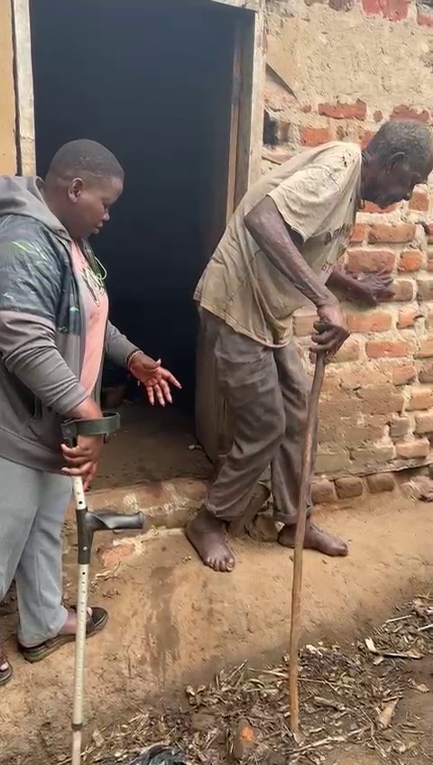 LPRC outreach worker supporting an elderly man learning to use crutches